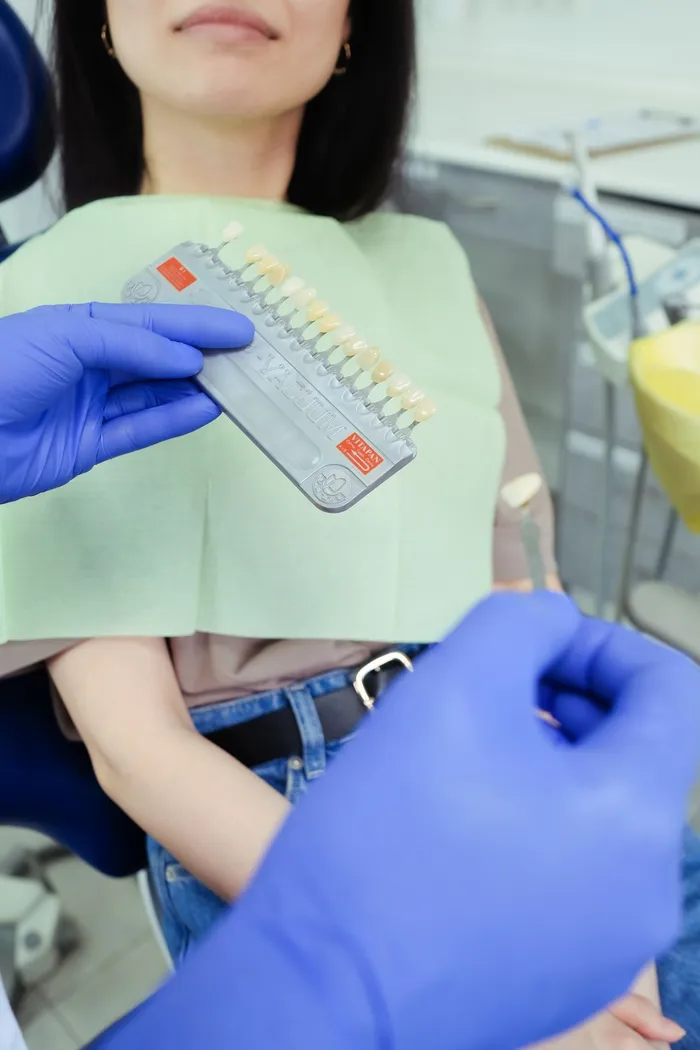 Dentist performing detailed shade and colour consultation with a patient — a marker of quality dental care and meticulous clinical standards at safe Turkish dental clinics