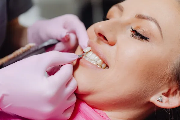 Dental veneer application procedure in progress — a cosmetic dentist applying porcelain veneers to a patient at a safe, accredited Turkish dental clinic